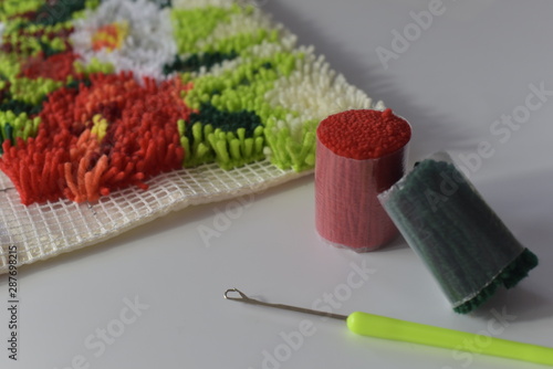 A rug in latch hoook technique with thread chunks and hook