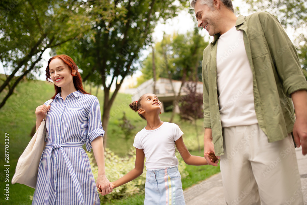African-American adopted daughter walking with parents African-American adopted daughter walking with parents