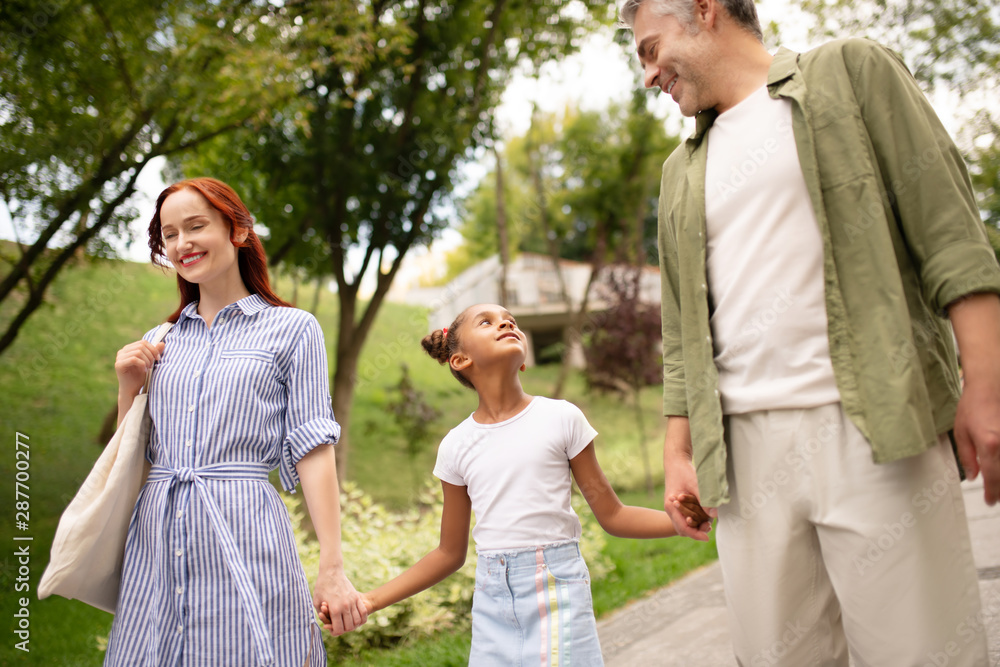 African-American adopted daughter walking with parents