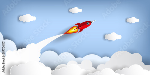 Paper art style of rocket flying over the sky while flying above a cloud.