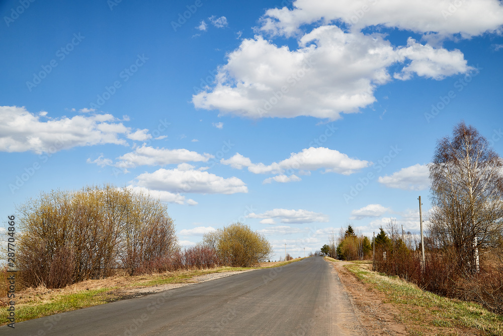Nature landscape with road, blue sky and white clouds in a spring or autumn day. Travel and Journey concept Nature landscape with road, blue sky and white clouds in a spring or autumn day. Travel and Journey concept