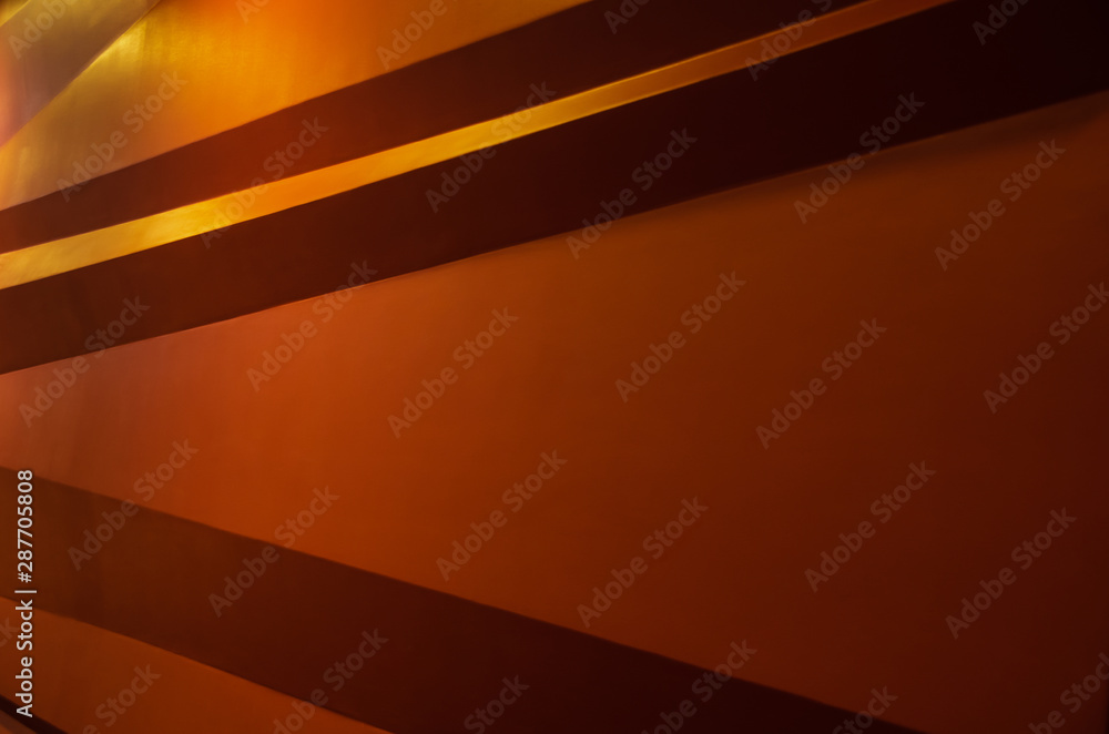 Geometric shaped orange wall illuminated architectural background Geometric shaped orange wall illuminated architectural background