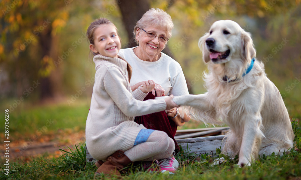 Autumn. Closeup portrait of happy grandmother with granddaughter and their favourite cute dog Autumn. Closeup portrait of happy grandmother with granddaughter and their favourite cute dog