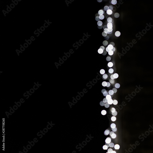 Abstract bokeh blurred glowing light on black surface backdrop