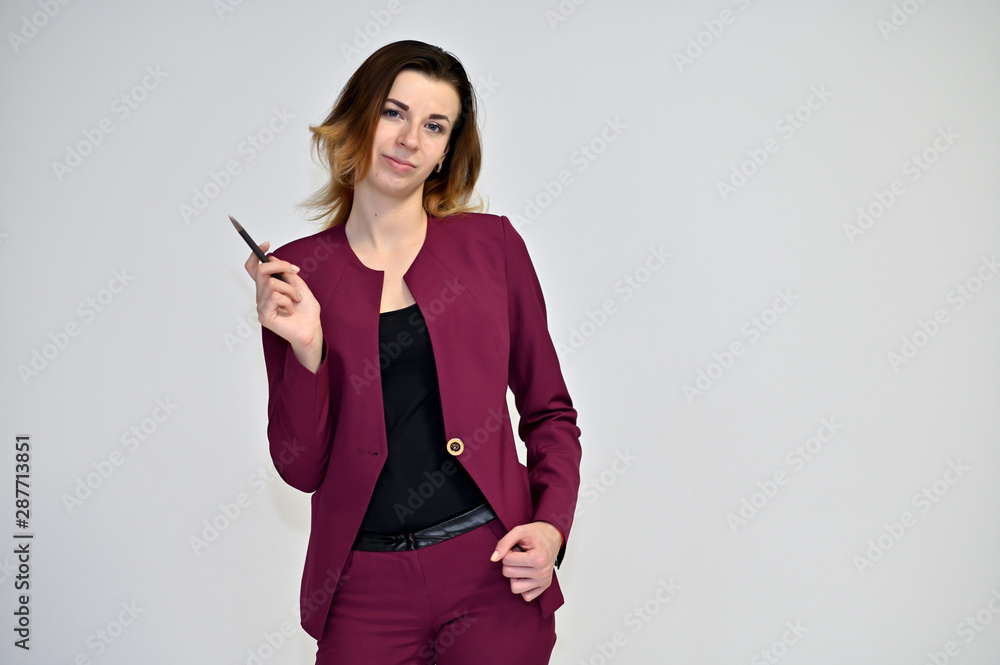Portrait of a pretty young brown-haired business woman on a white background in a dark business suit. He stands in different poses, talking, different emotions. Portrait of a pretty young brown-haired business woman on a white background in a dark business suit. He stands in different poses, talking, different emotions.