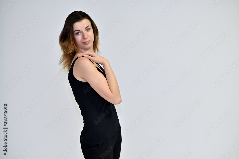 Portrait of a pretty brown-haired young woman on a white background in a black t-shirt. He stands in different poses, talking, different emotions. Portrait of a pretty brown-haired young woman on a white background in a black t-shirt. He stands in different poses, talking, different emotions.