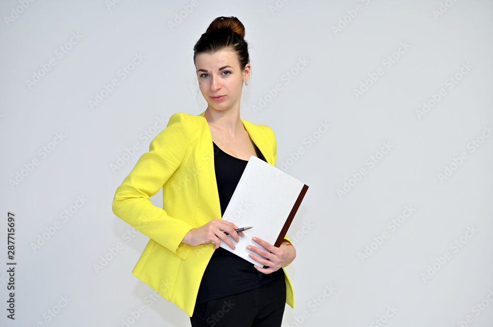 Portrait of a pretty young brown-haired secretary woman on a white background in a yellow jacket with gathered hair. He stands in different poses, talking, different emotions. Portrait of a pretty young brown-haired secretary woman on a white background in a yellow jacket with gathered hair. He stands in different poses, talking, different emotions.