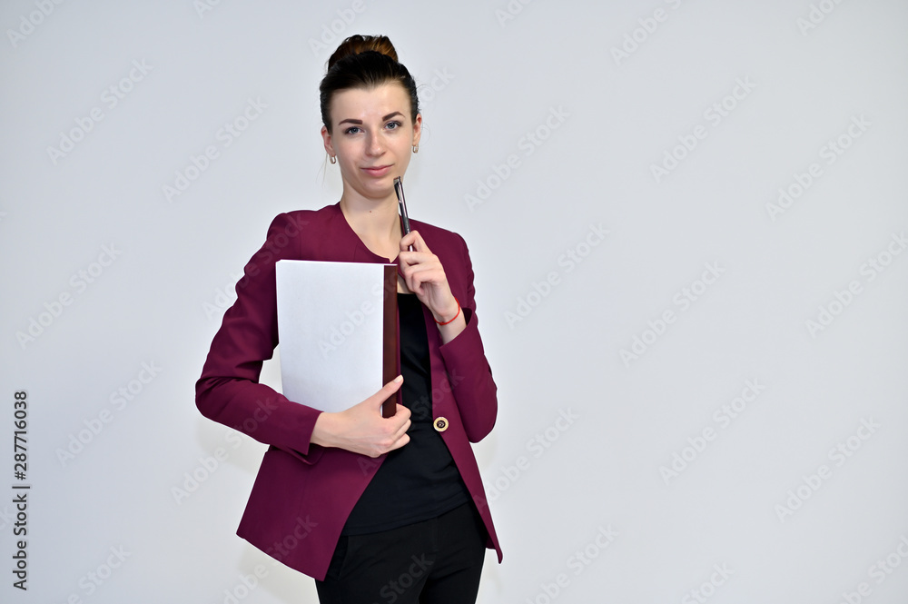 Portrait of a pretty young brown-haired secretary woman on a white background in a burgundy jacket with gathered hair. He stands in different poses, talking, different emotions. Portrait of a pretty young brown-haired secretary woman on a white background in a burgundy jacket with gathered hair. He stands in different poses, talking, different emotions.