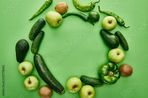 top view of apples, avocados, cucumbers, lime, peppers, kiwi and zucchini