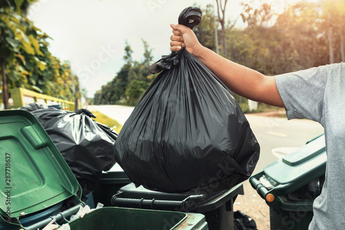 Billede på lærred woman hand holding garbage in black bag for cleaning in to trash
