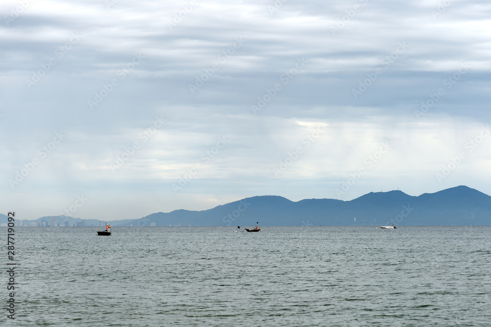 Seascape on the coast of Vietnam with a view of the mountains, boats and the city of Da Nang. Hoi An, Vietnam