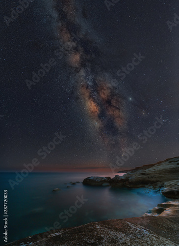 Fototapeta Naklejka Na Ścianę i Meble -  Milky way rising above White Stones beach in Limassol, Cyprus