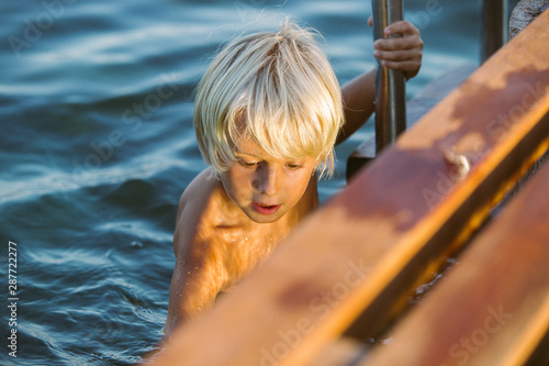 niño nadando en embarcadero