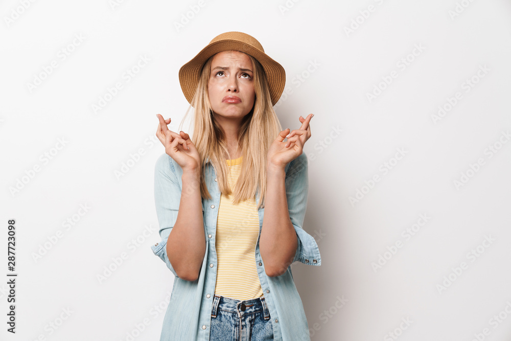 Sad young pretty woman wearing hat posing isolated over white wall background make hopeful please gesture. Sad young pretty woman wearing hat posing isolated over white wall background make hopeful please gesture.