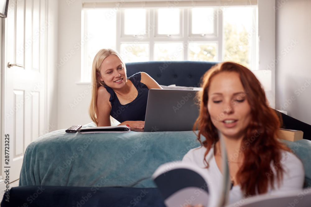 Two Female College Students In Shared House Bedroom Studying Together Two Female College Students In Shared House Bedroom Studying Together