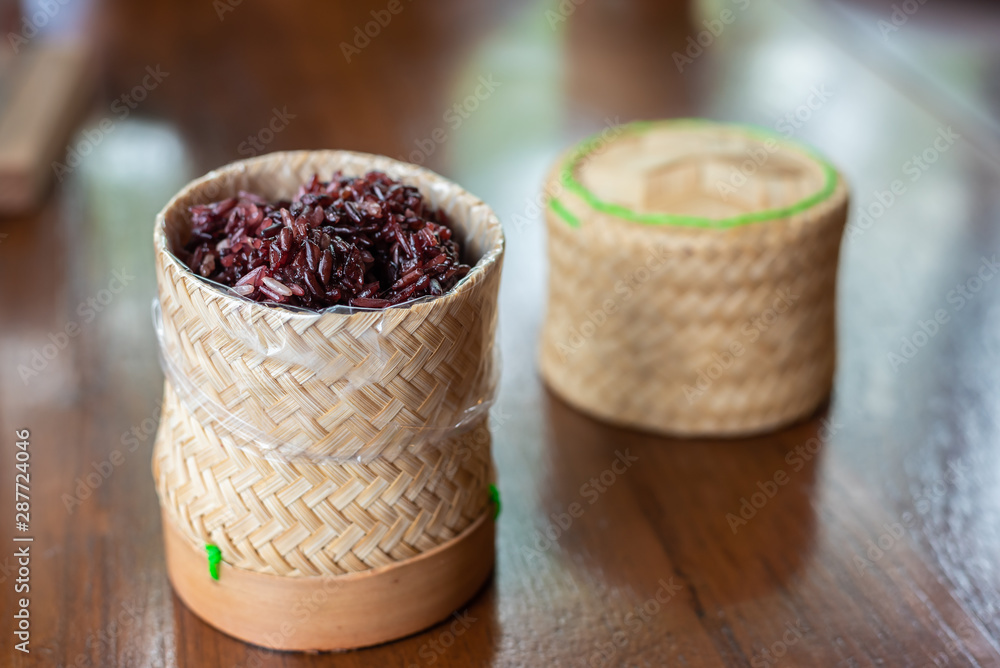 Cooked and hot black sticky rice ready to eat in a bamboo basket.
