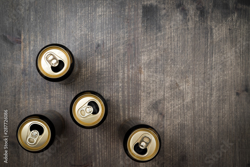 Opened Cans of beer on wooden table photo