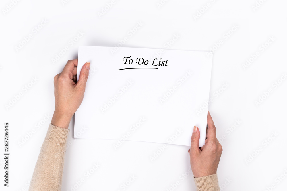To Do List Concept - 2020 number and text on notepad. Woman's hands with perfect manicure holding notepad as mockup for your design. White background, flat lay style. To Do List Concept - 2020 number and text on notepad. Woman's hands with perfect manicure holding notepad as mockup for your design. White background, flat lay style.