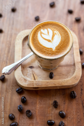 Latte art on a wooden table and coffee beans