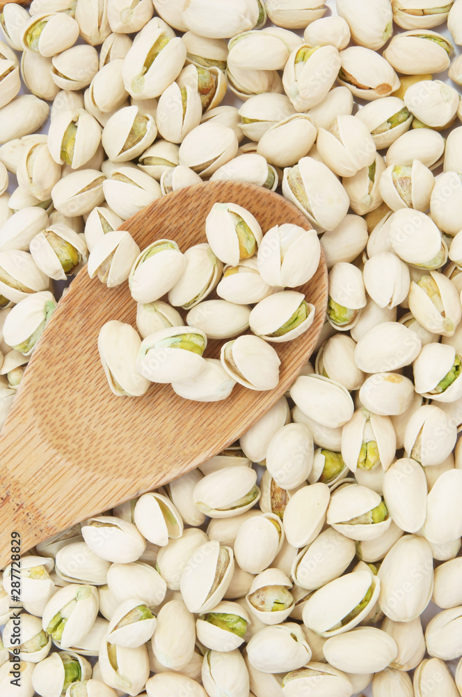 Pistachio nuts with wooden spoon