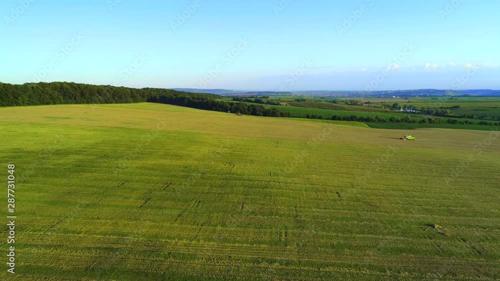 Aerial view of vivid nature and agriculture with working combiners. 4K. Aerial view of vivid nature and agriculture with working combiners. 4K.