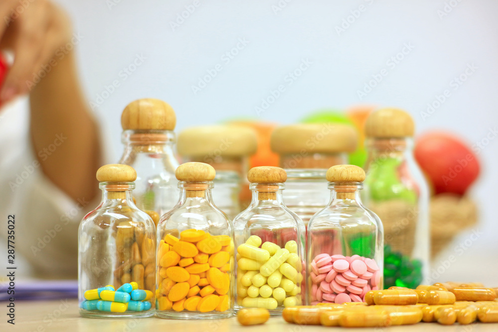 Group of Vitamins in a glass bottles on the table in the laboratory Group of Vitamins in a glass bottles on the table in the laboratory