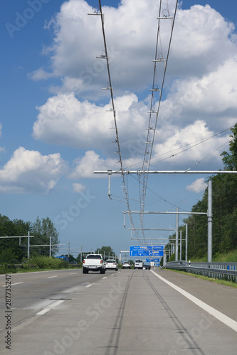 E-Highway with electric overhead contact wire for hybrid trucks, test track in Luebeck, Germany, blue sky with clouds, copy space, vertical