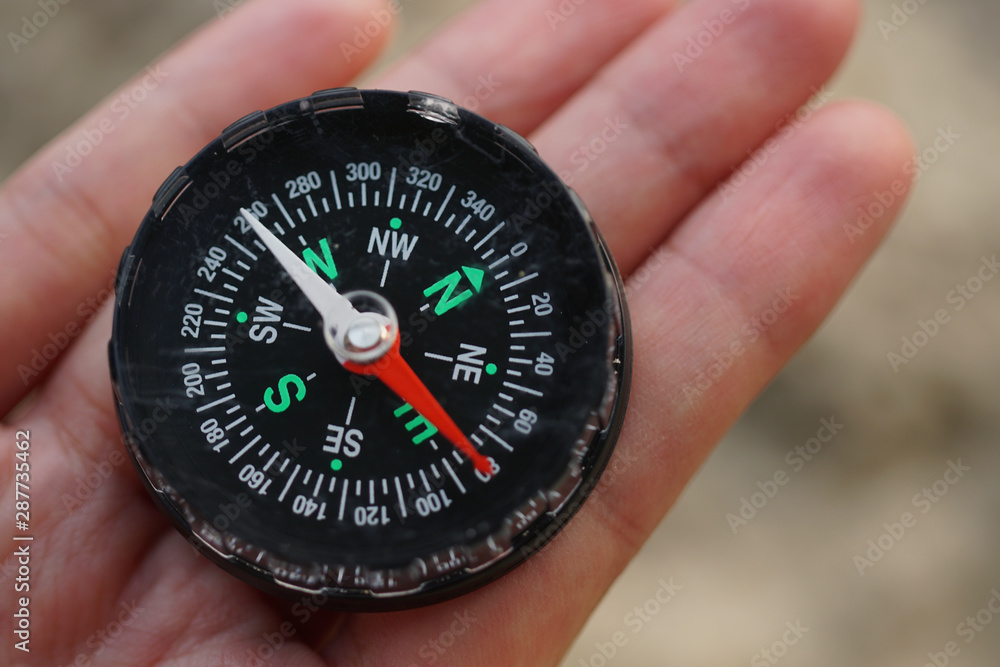 A compass on a beach sand. Selective focus to the compass A compass on a beach sand. Selective focus to the compass