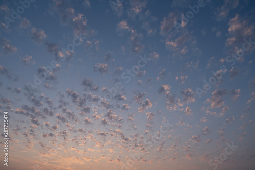 Small bright group of clouds at sunset cloudscape. 