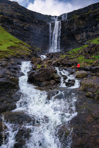 Tourist at the Fossa Waterfall on island Bordoy in the Faroe Islands