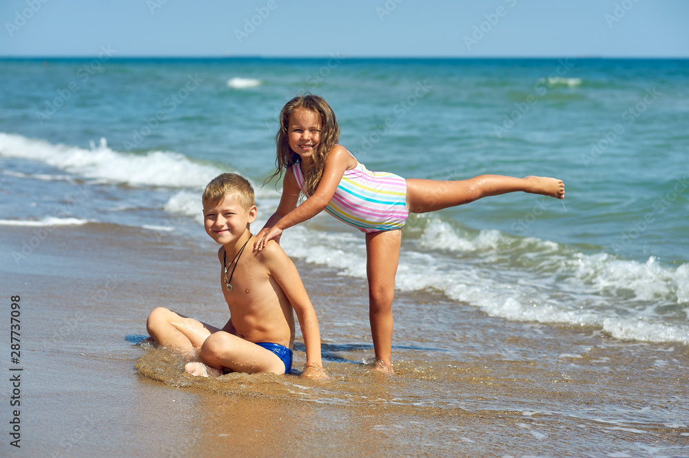 Cheerful children relax on the sea coast . Children's summer vacation