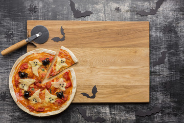 Halloween pizza slices on wooden board