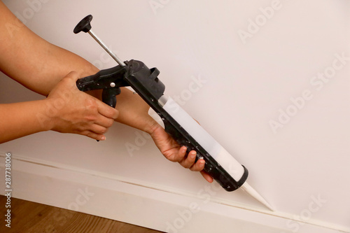 A female contractor using a mastic gun photo