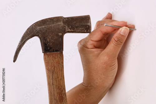 A female contractor using a hammer to hammer in a nail