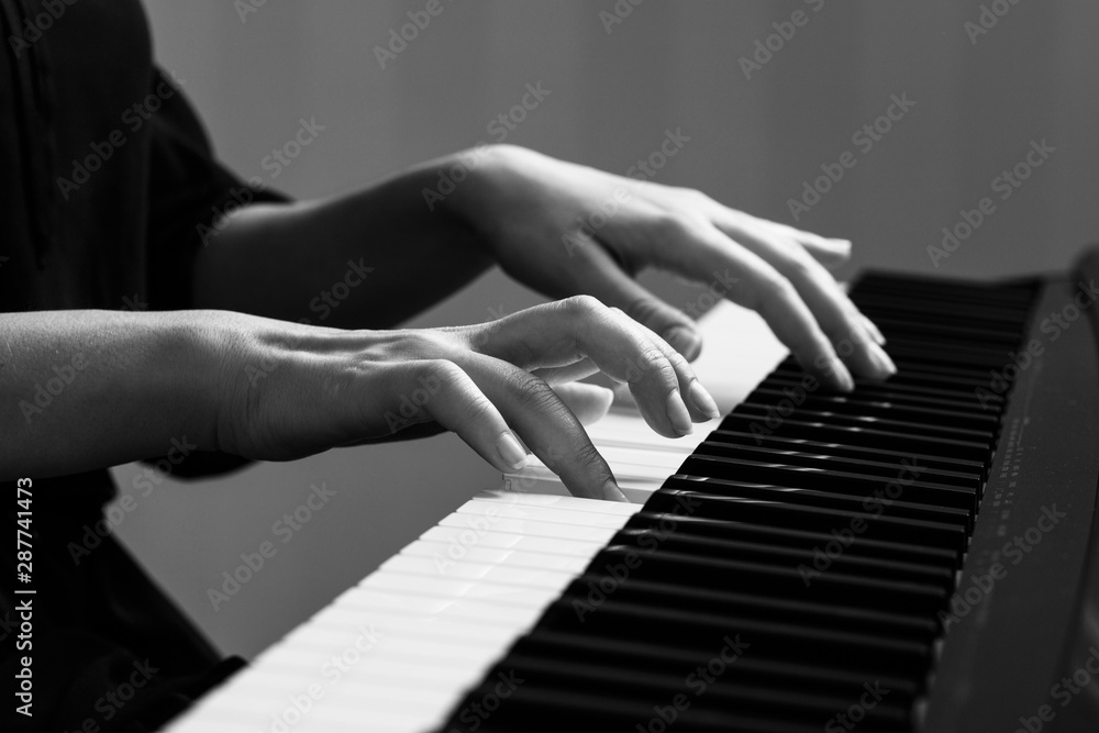 Fototapeta premium Young woman playing piano