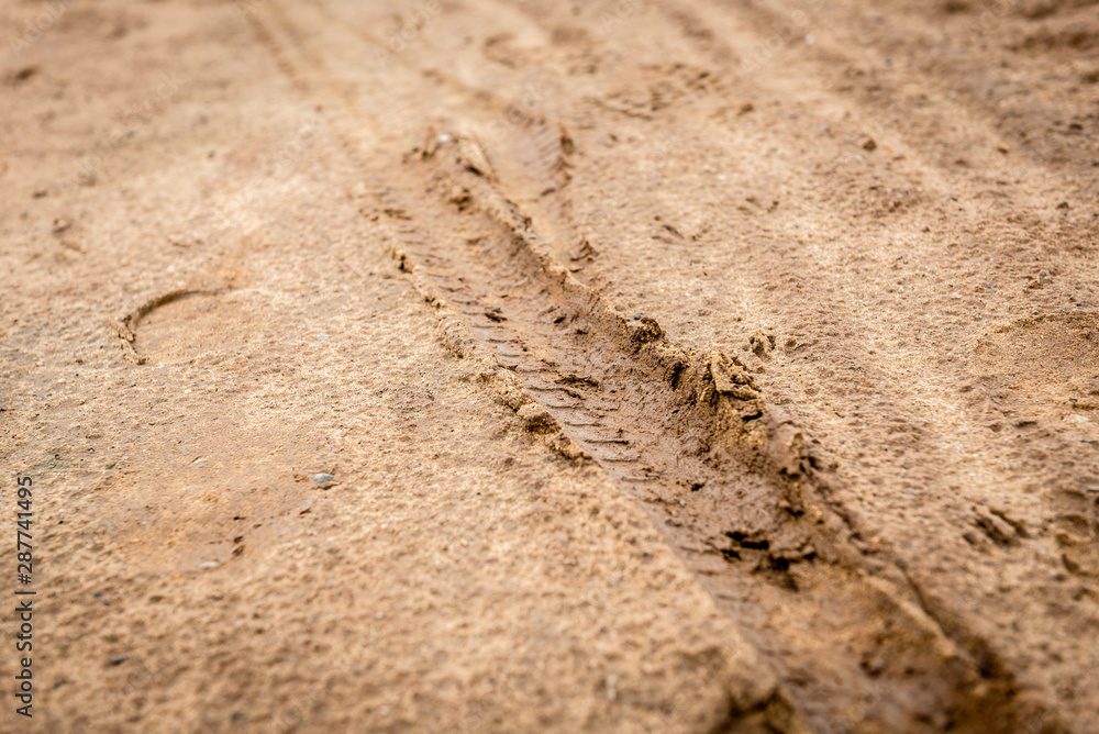 Tracks of car tires on a wet, swampy road with brown water. Country dirt road with paddles after rain Tracks of car tires on a wet, swampy road with brown water. Country dirt road with paddles after rain