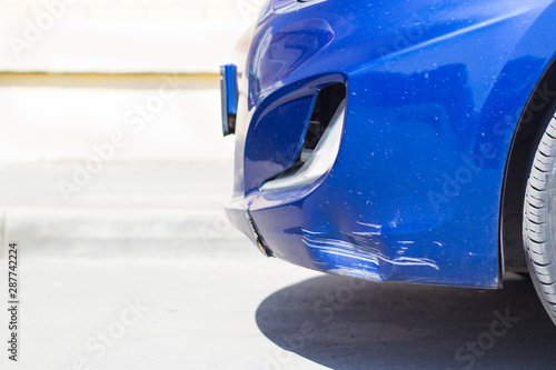 Damaged front bumper of a blue car close-up. scratches on the surface of the car. photo
