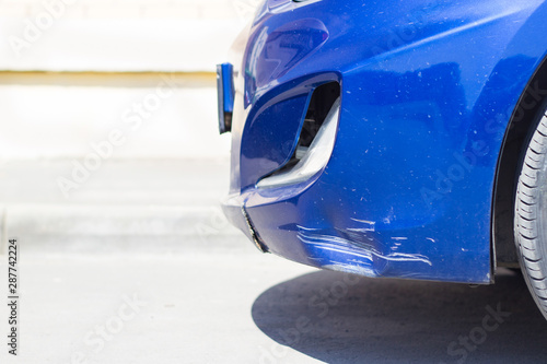 Cuadro en lienzo Damaged front bumper of a blue car close-up