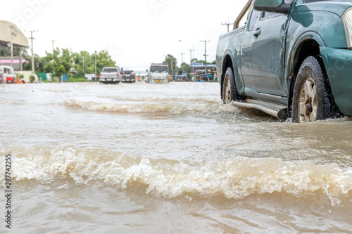 Cars driving on a flooded road, The broken car is parked in a flooded road. .