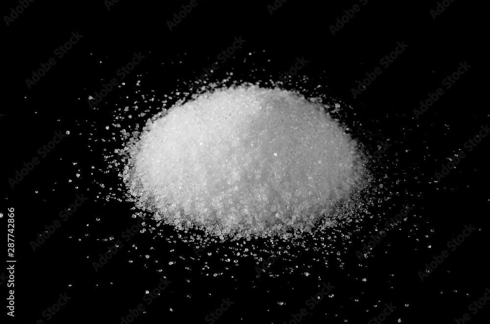 Sugar crystals, pile isolated on black background