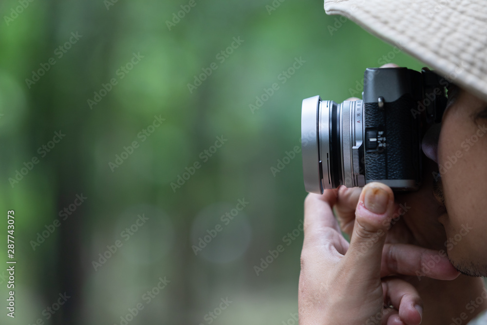 Young Asian male traveler and photographer sitting on the classic style racer motorbike holding camera taking photo on road ,Travel photography concept Young Asian male traveler and photographer sitting on the classic style racer motorbike holding camera taking photo on road ,Travel photography concept
