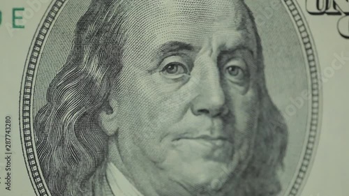 Shaking macro shot of Benjamine Franklin's face on the US one hundreed dollar bill photo