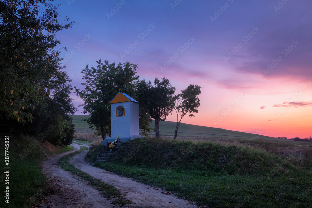 Beautiful purple sunset over christian chapel in Velka Lehota village, Slovakia