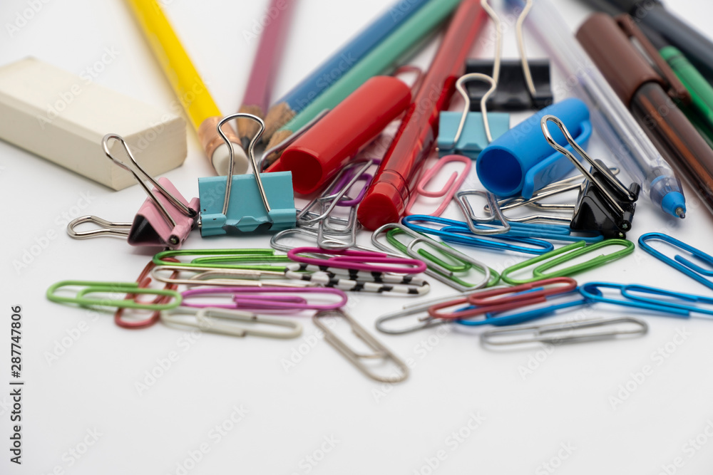 Colorful office tools set, pen, binder, paper clip, pencils, eraser isolated on white background Colorful office tools set, pen, binder, paper clip, pencils, eraser isolated on white background