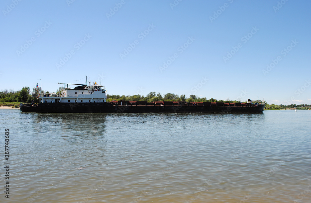 Barge floating on the river. Cargo ship carries cargo.