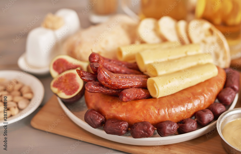 Sausage and cheese slices with light beer, pistachios, mustard and ciabatta bread for Oktoberfest Sausage and cheese slices with light beer, pistachios, mustard and ciabatta bread for Oktoberfest