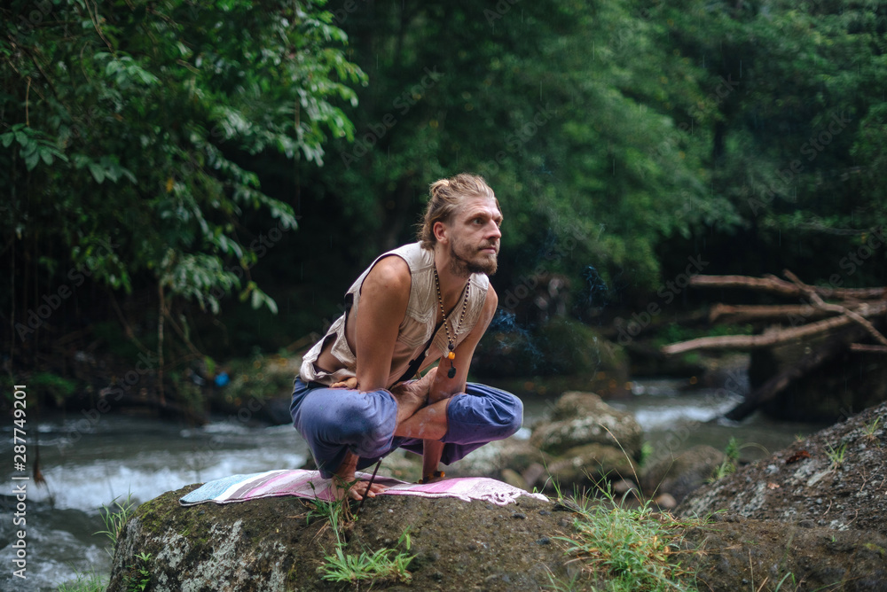 Yoga practice and meditation in nature. Man practicing near river Yoga practice and meditation in nature. Man practicing near river