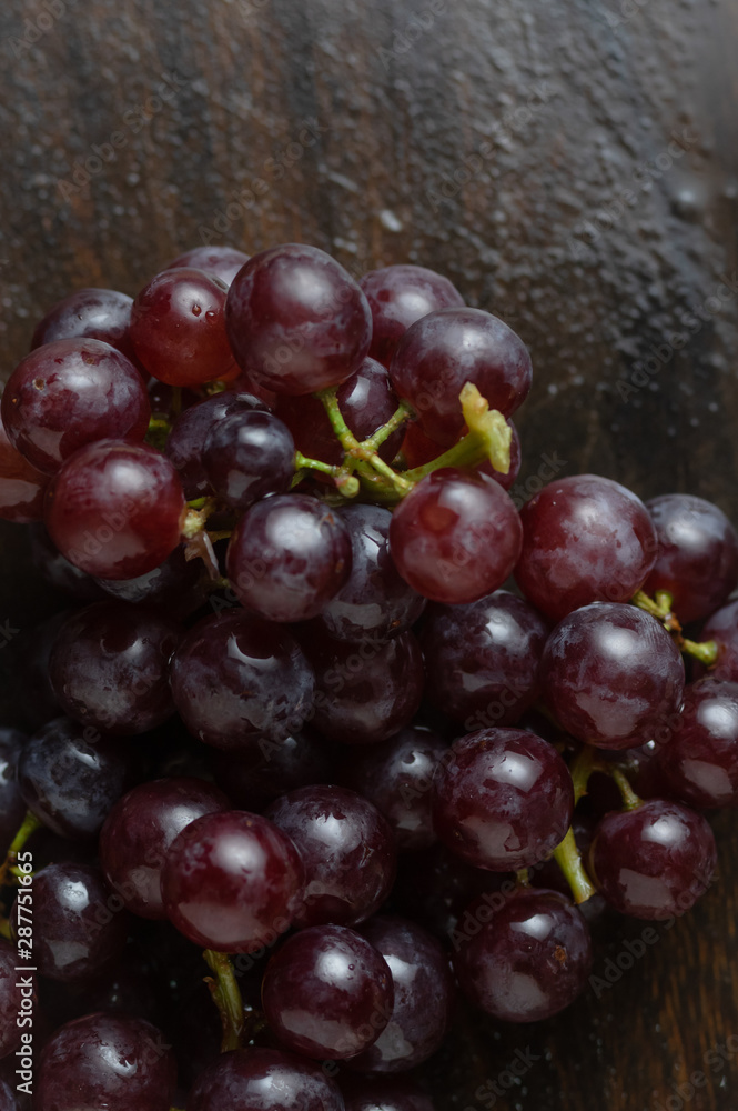 The bunch of red grape on wooden floor The bunch of red grape on wooden floor