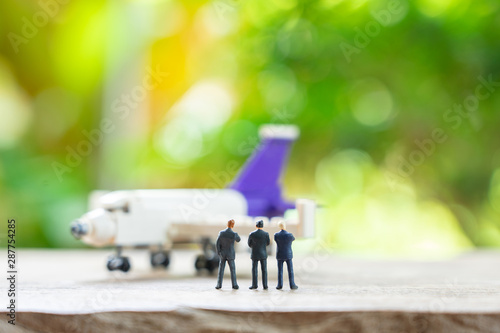Miniature people businessmen standing with Plane model as background strategy concept and Business concept with copy space and white space.