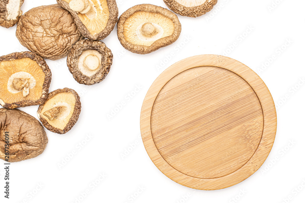 Lot of whole dry mushroom shiitake with bamboo plate flatlay isolated on white background